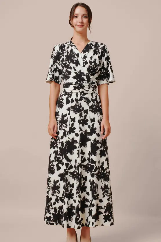 A model wears the Long Marilyn Dress in stretch jersey, a flowing, floor-length garment.