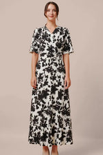 A model wears the Long Marilyn Dress in stretch jersey, a flowing, floor-length garment.