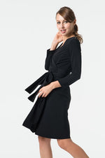 A woman models a sleek black wrap dress, showcasing its flattering silhouette and elegant drape.