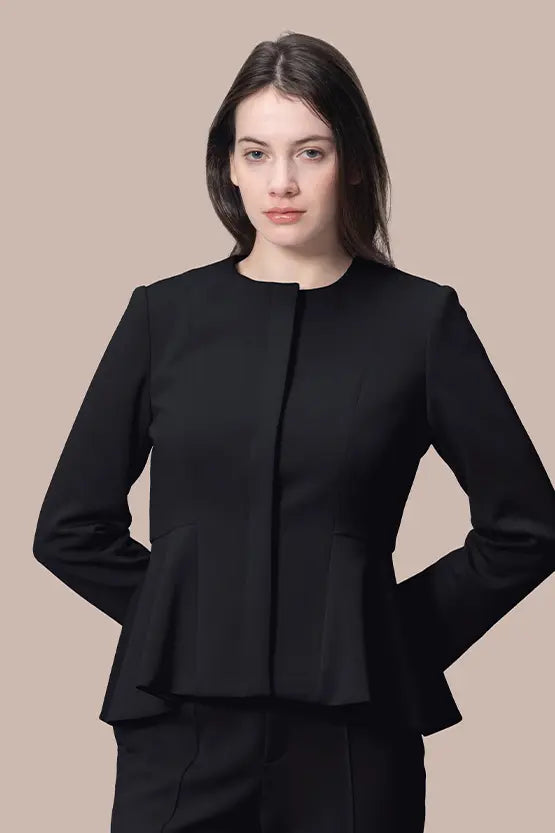Model wearing a black Space Material Peplum Jacket, featuring a cinched waist and structured shoulders.