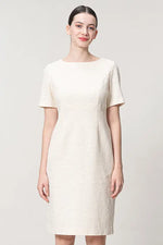 A woman models the Stretch Tweed: Essential Dress, a knee-length navy blue tweed sheath dress with a crew neckline.