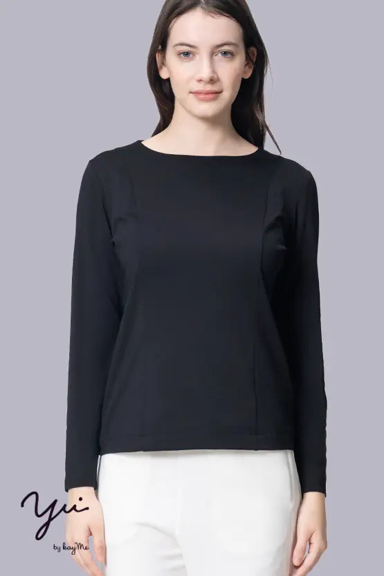 A woman models the Wellness Tech Boat Neck Top in a neutral color, showcasing its relaxed fit and classic neckline.