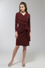 A woman models a flowy, floral print wrap dress with a V-neckline and tie waist.