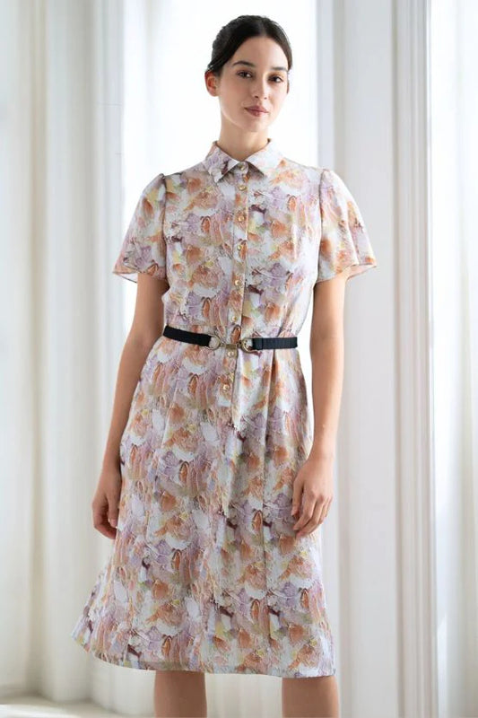 Woman in a flowing Stretch Georgette: Womanhood Shirt Dress in a soft lavender hue, styled open with a belt.