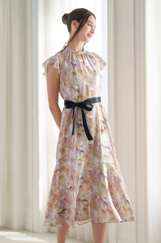 Woman wearing a sleeveless floral dress with a tied waist
