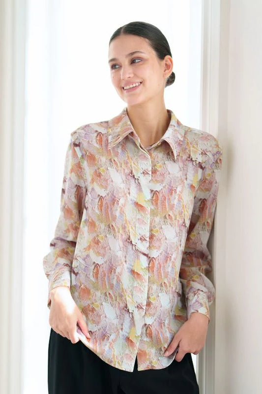 Woman wearing a floral button-up blouse with long sleeves