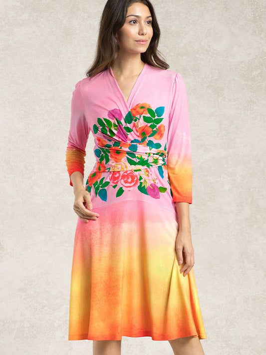 Sunset Bouquet Cache-Coeur Dress: A woman models the floral print dress with a flattering V-neckline and wrap-style bodice.