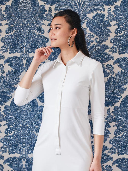 White long shirt dress with a button-down front and a flowing silhouette.
